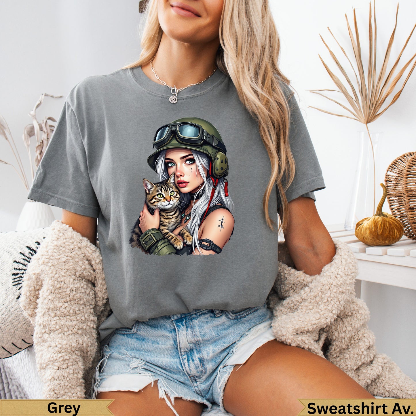 Woman in a grey t-shirt holding a cat, wearing a military helmet.