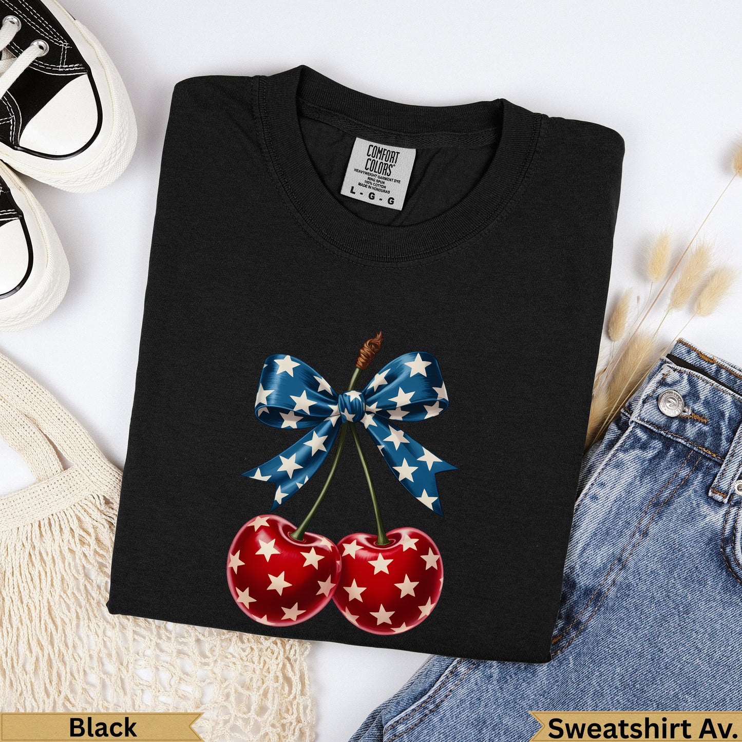Black t-shirt with red cherries and a blue bow with white stars.