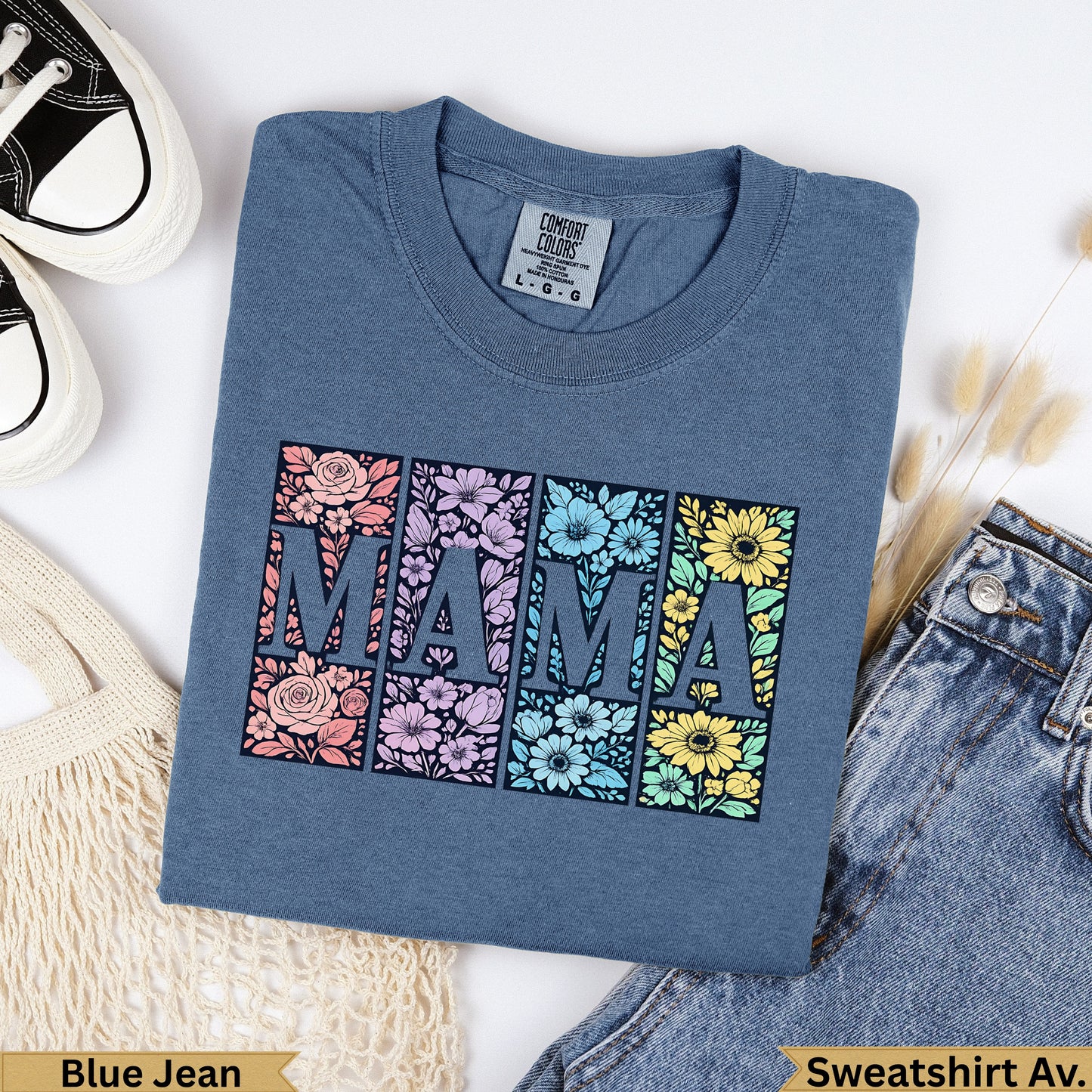 Blue t-shirt with "MAMA" in floral-filled squares, with jeans and a bag.