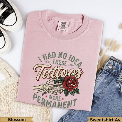 Pink sweatshirt with "I had no idea these tattoos were permanent" text and rose design.