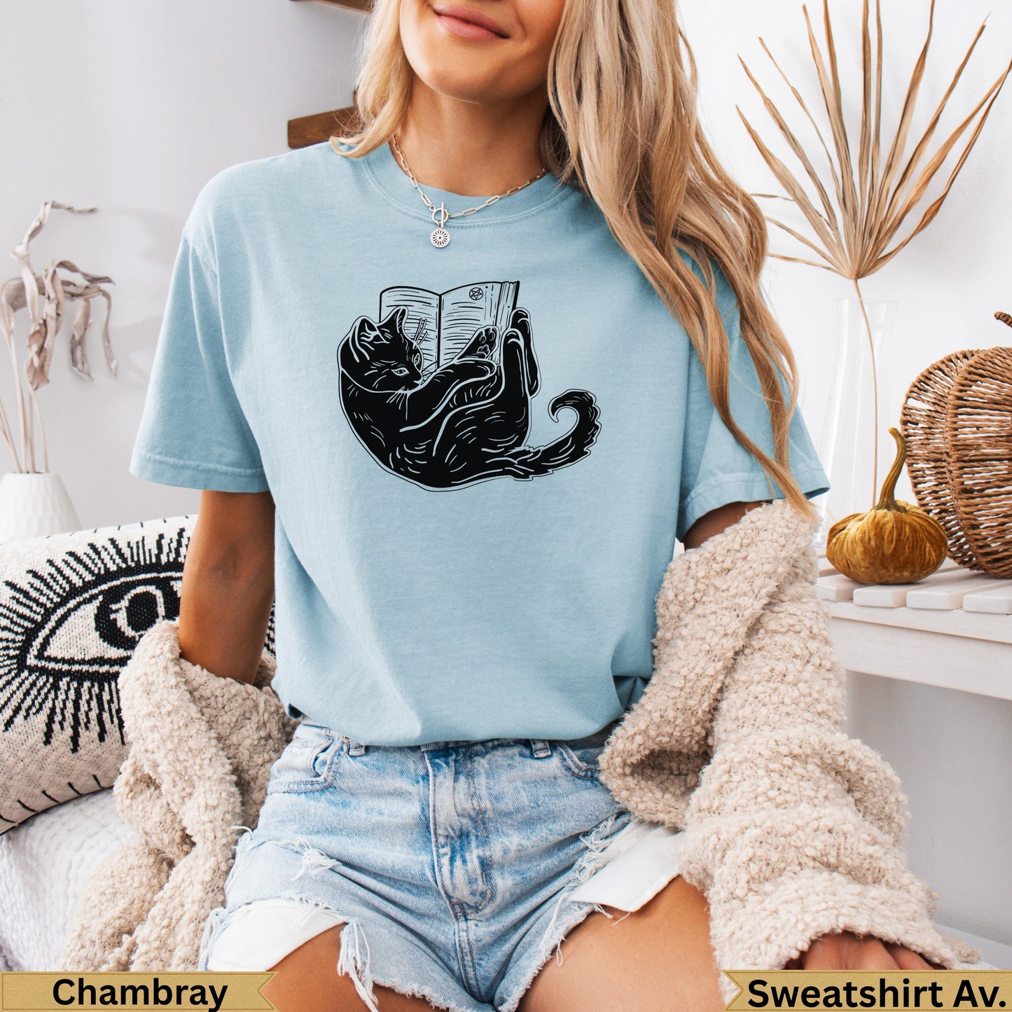 Light blue t-shirt with a black cat reading a book graphic.
