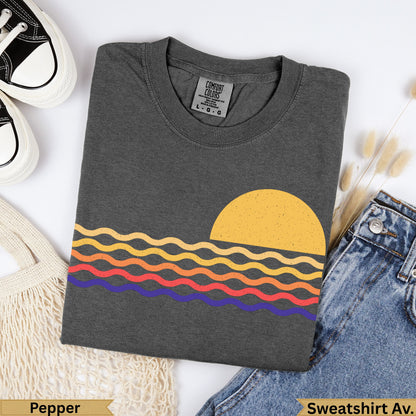 Charcoal t-shirt with orange sun and striped waves design, "Pepper" and "Sweatshirt Av." text.