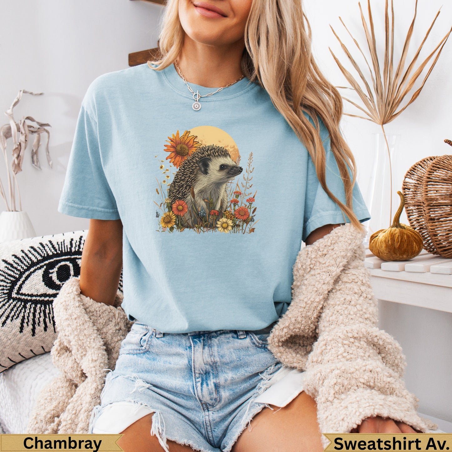 Light blue t-shirt with hedgehog, sunflower, and floral graphic.