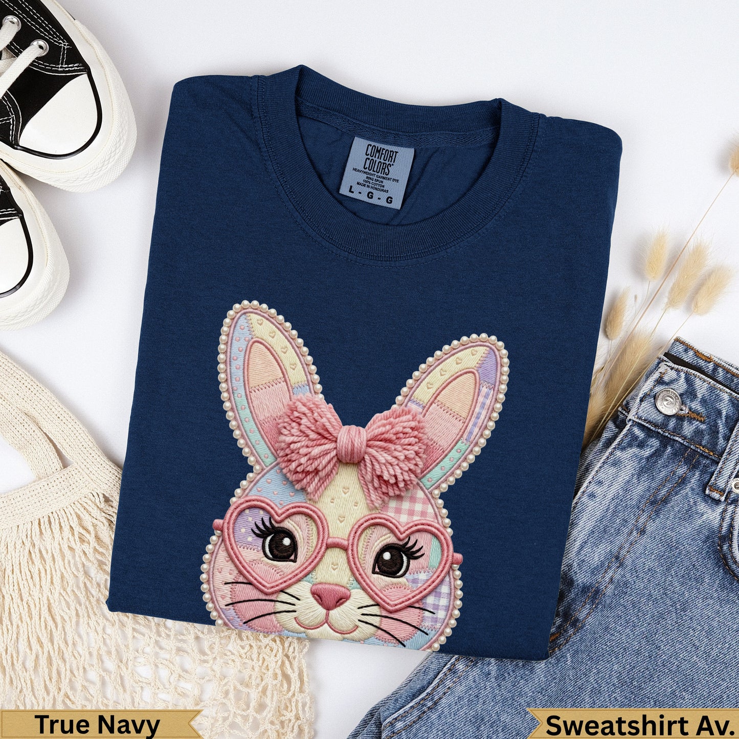 Navy crewneck sweatshirt with embroidered bunny wearing heart glasses and pink bow.