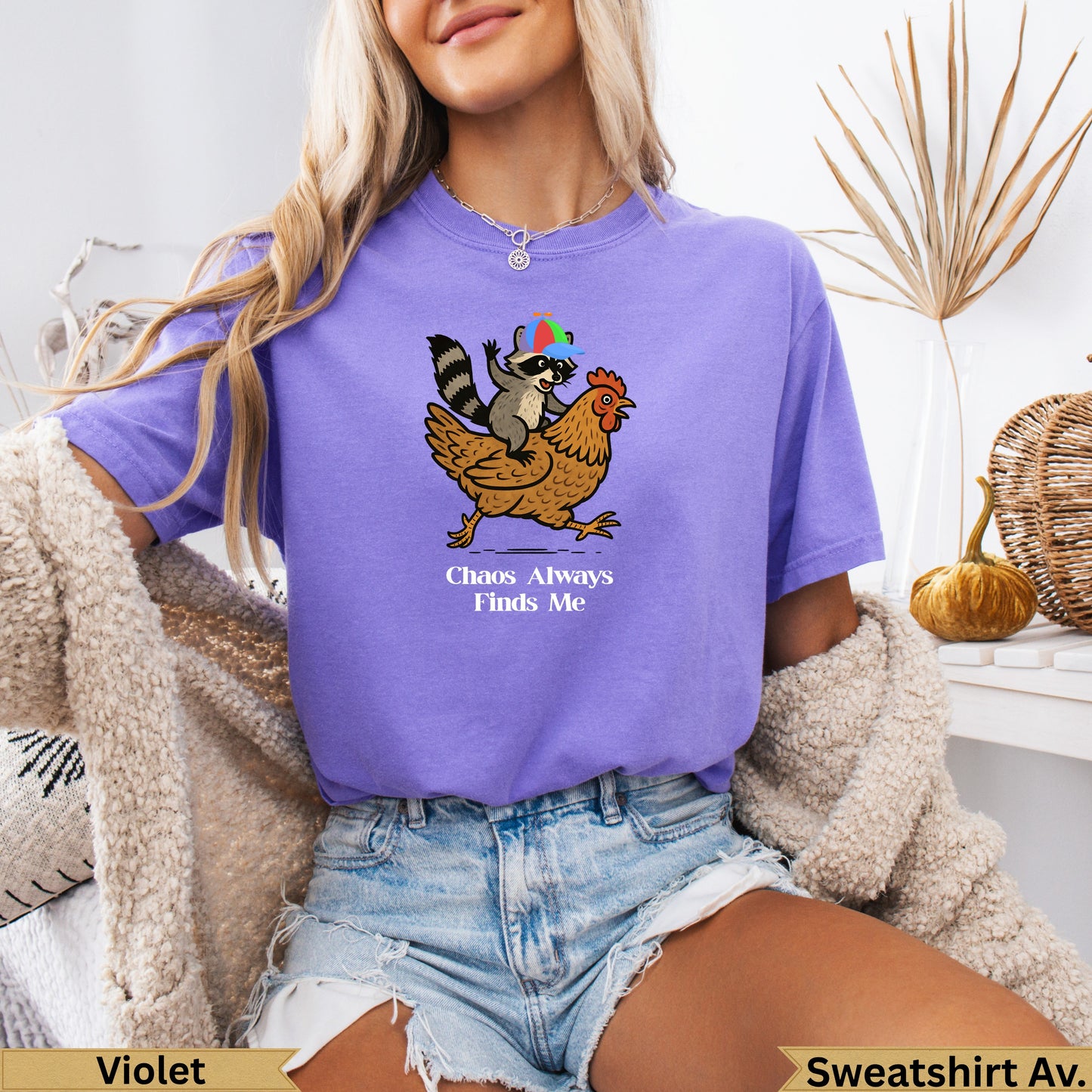 Raccoon wearing party hat rides chicken, text "Chaos Always Finds Me".