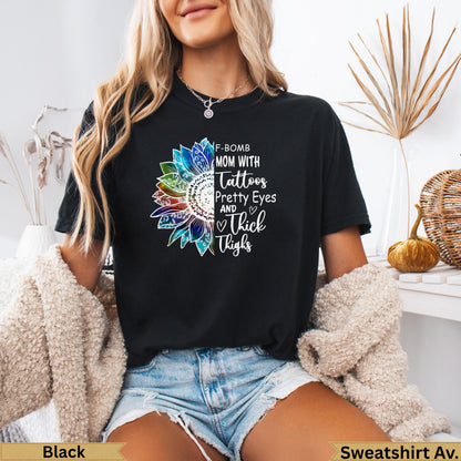Black t-shirt with sunflower design and text "F-BOMB MOM WITH Tattoos Pretty Eyes AND Thick Thighs".