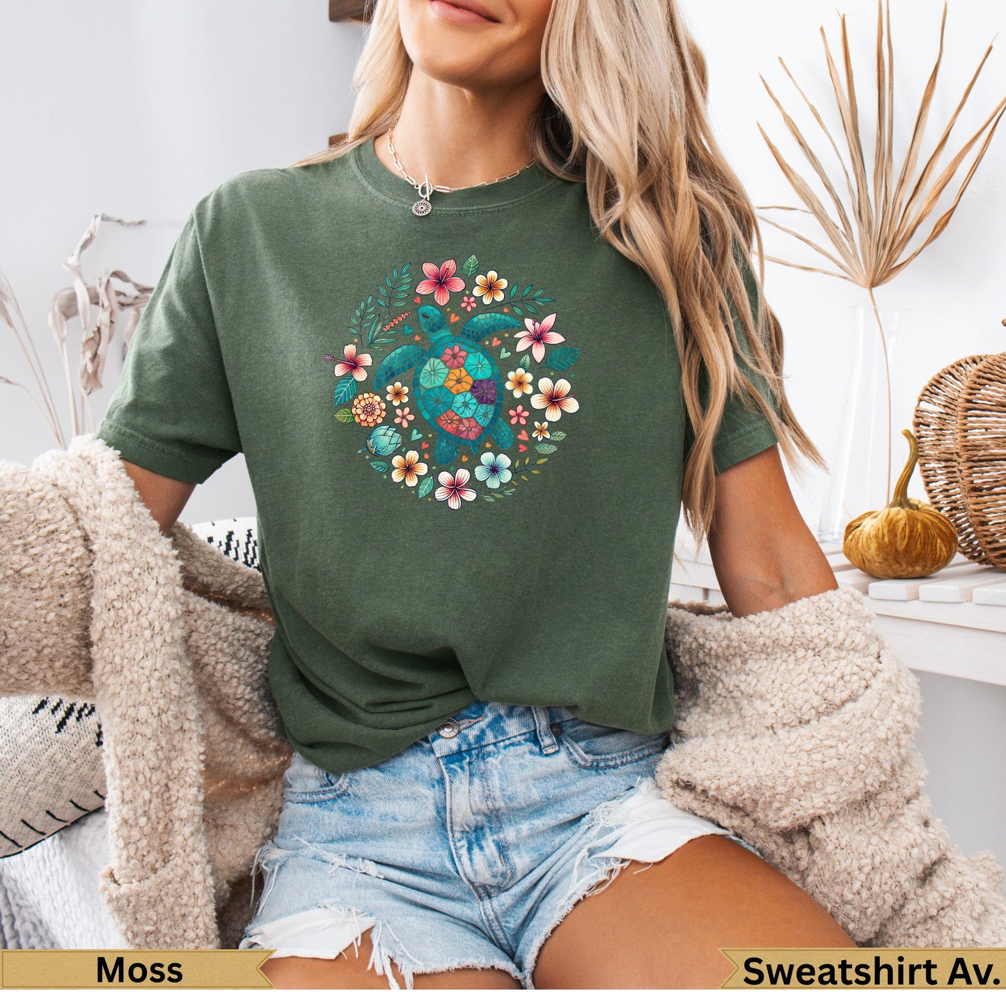 Green t-shirt with colorful floral and sea turtle design.