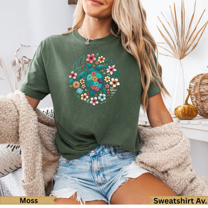 Green t-shirt with colorful floral and sea turtle design.