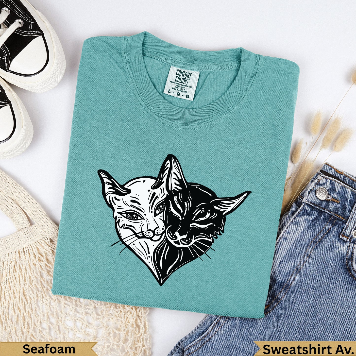 Teal t-shirt with black and white cat face design, "Seafoam" and "Sweatshirt Av.".