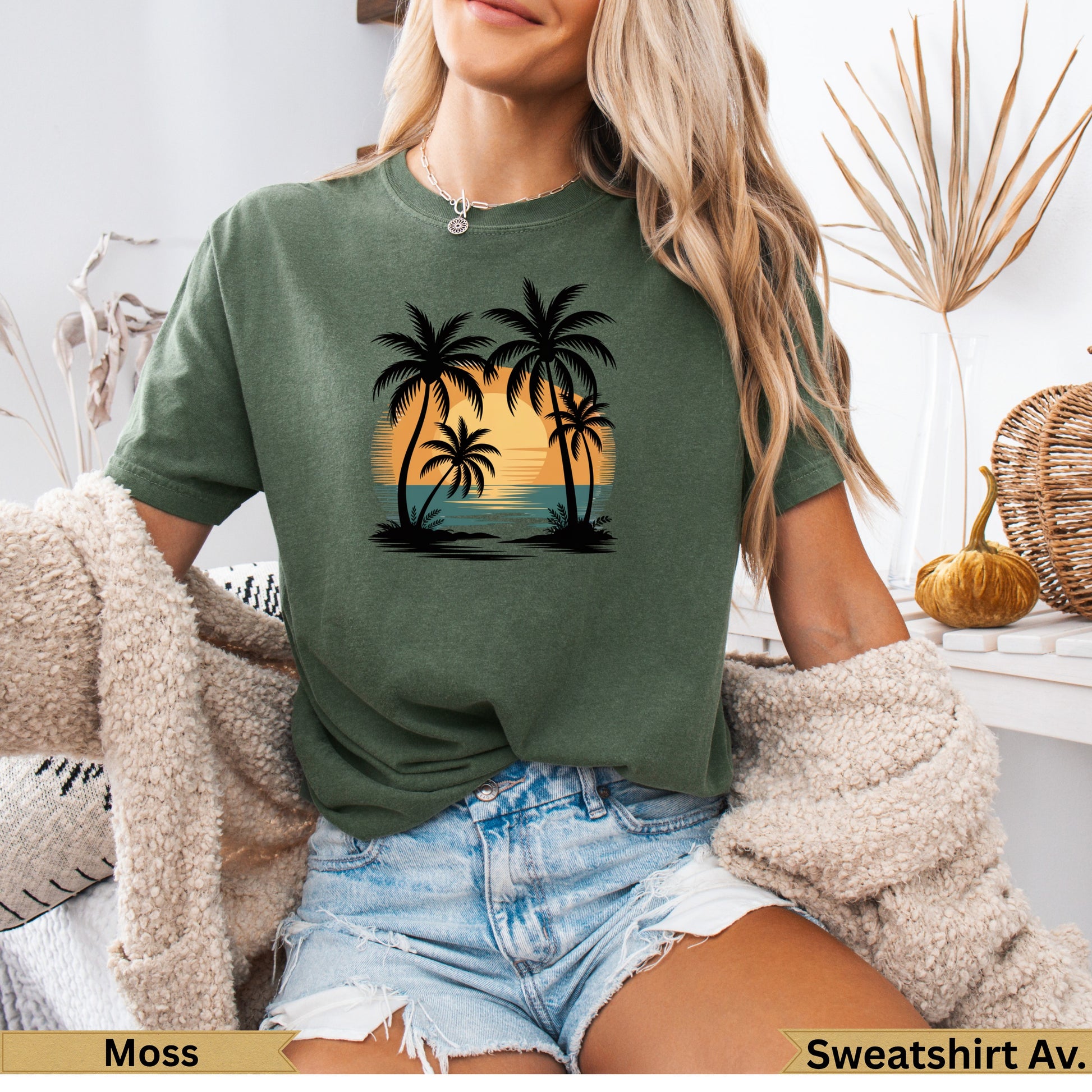 Moss green t-shirt with a sunset and palm tree graphic.