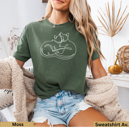 Green t-shirt with two intertwined white cats outline graphic.