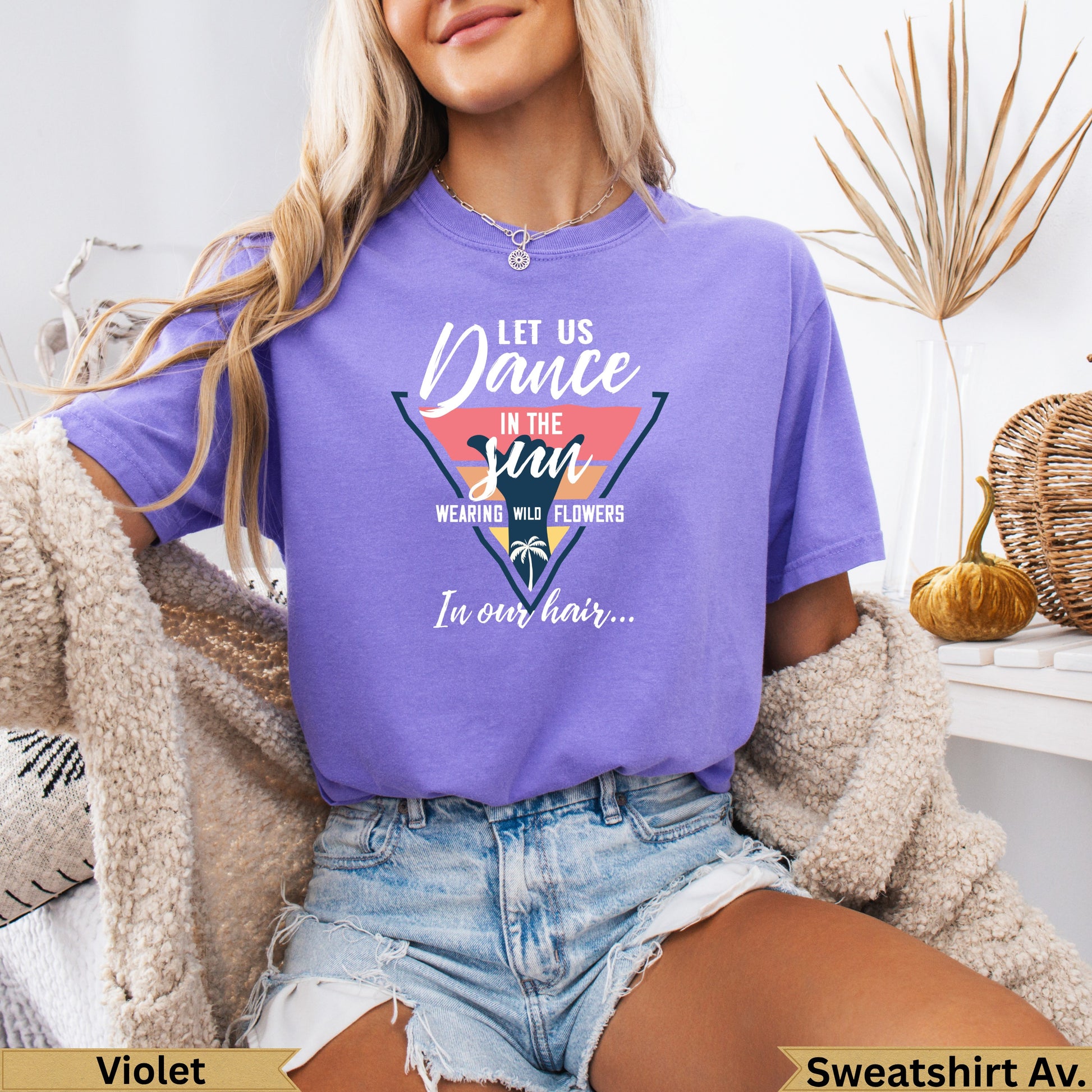 Purple t-shirt with "Dance in the sun" text and floral design.