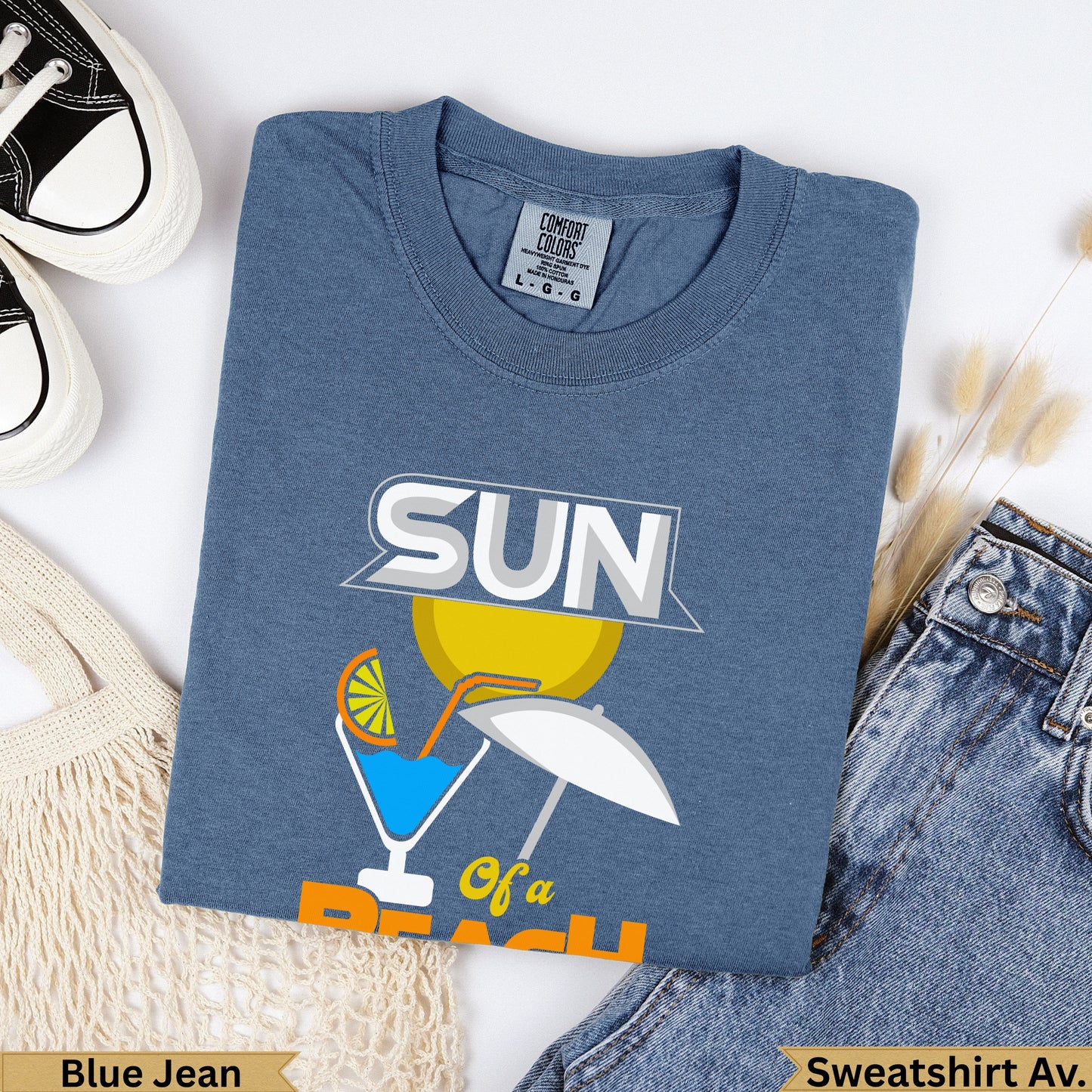 Blue t-shirt with "SUN of a beach" graphic and a white umbrella.