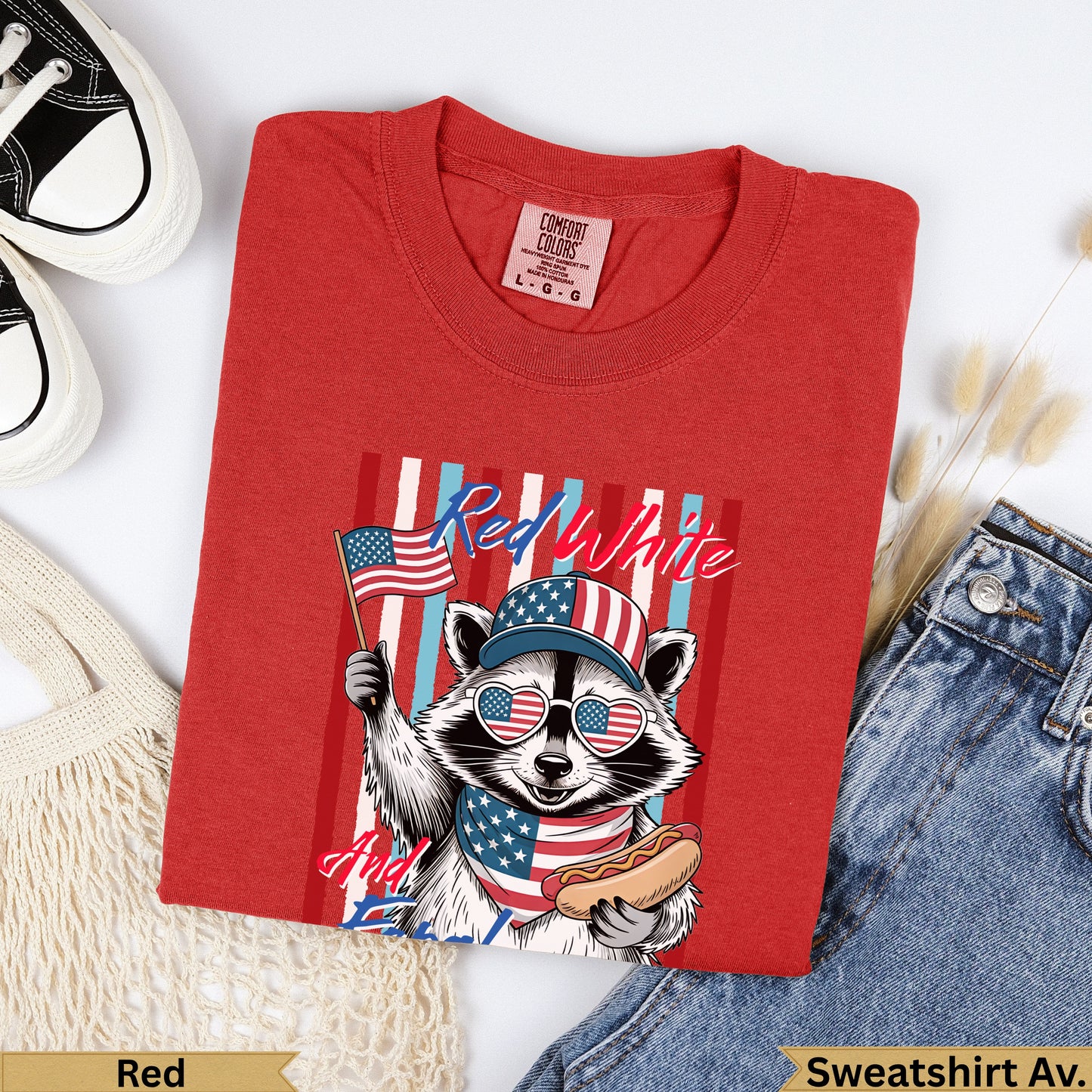 Red t-shirt with raccoon wearing American flag hat and holding hot dog.