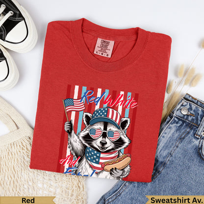 Red t-shirt with raccoon wearing American flag hat and holding hot dog.
