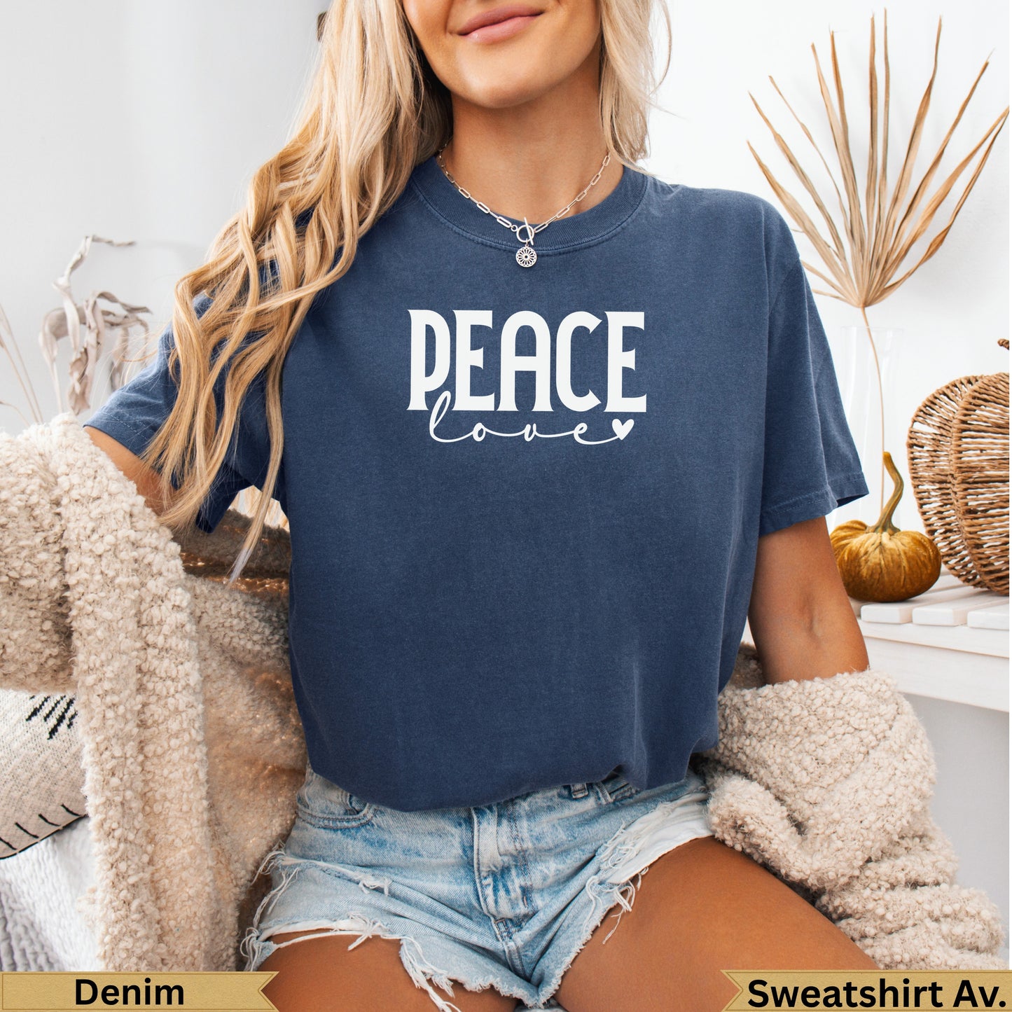 Woman wearing a navy t-shirt with white "PEACE love" graphic.
