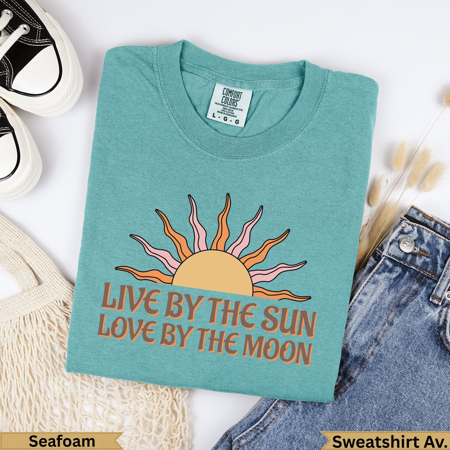 Teal t-shirt with "Live By The Sun, Love By The Moon" and sun graphic.
