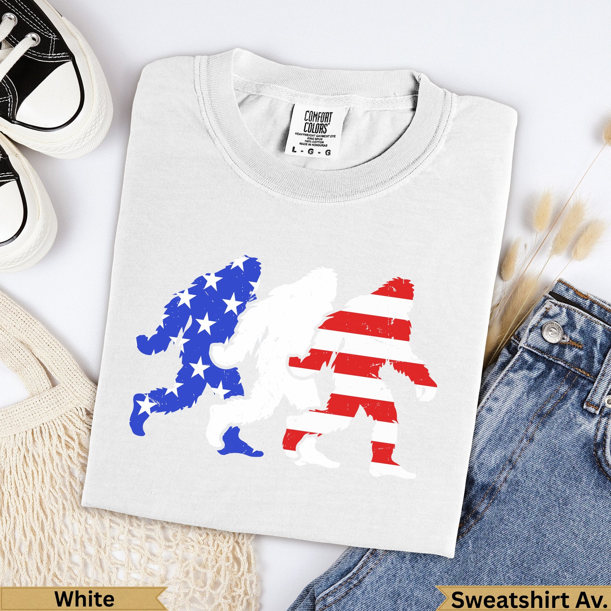 White t-shirt with three Bigfoot silhouettes, two in American flag pattern.