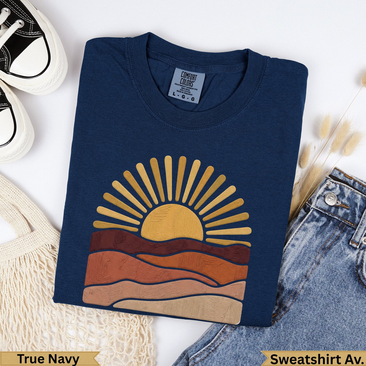Navy t-shirt with a golden sun rising over layered brown hills.
