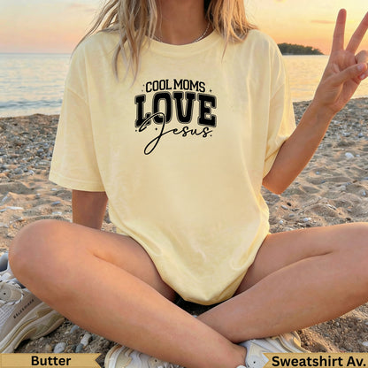 Yellow t-shirt with "Cool Moms Love Jesus" graphic on beach.