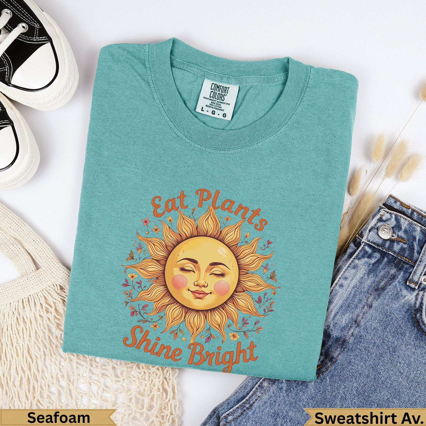 Teal t-shirt with sun graphic and text "Eat Plants Shine Bright".