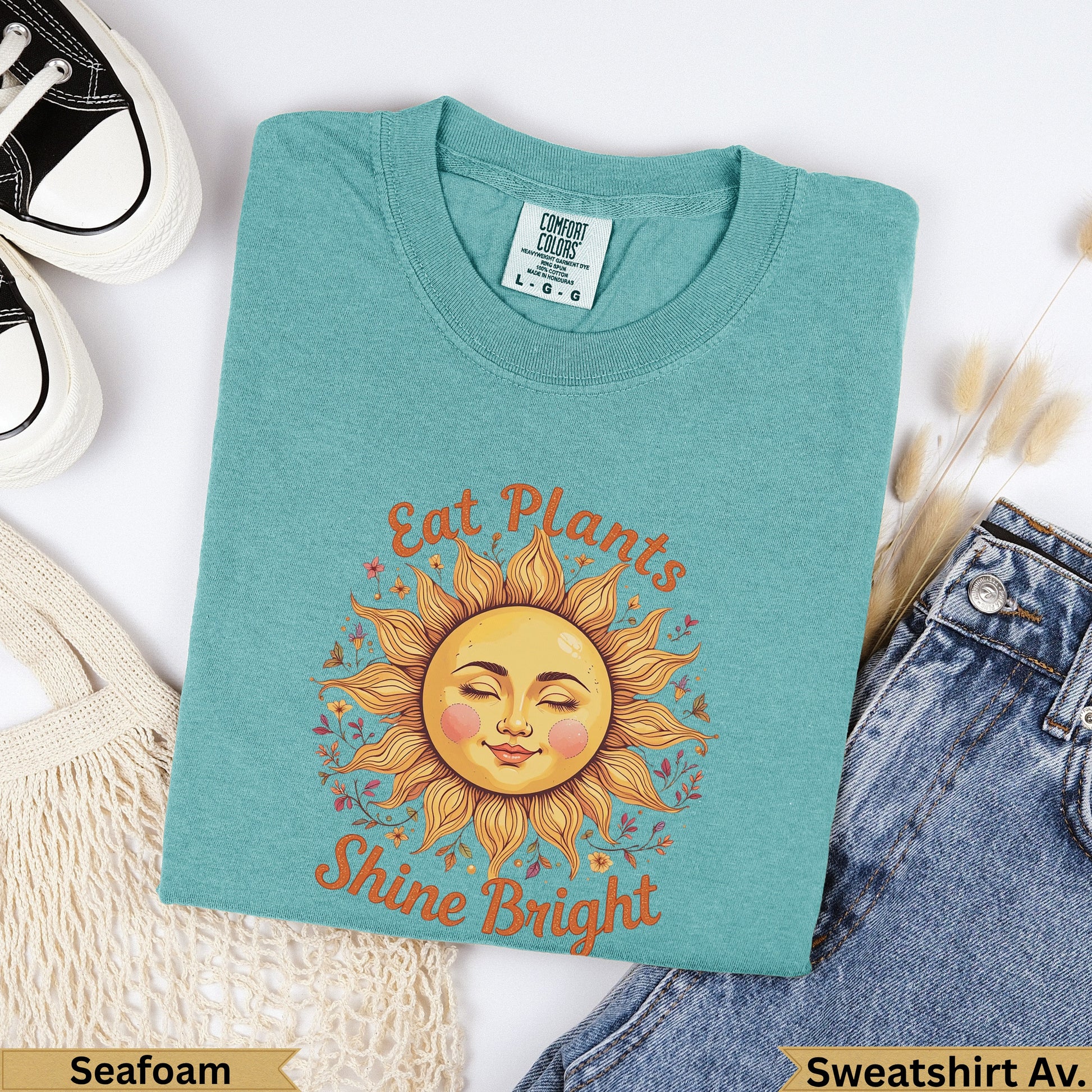 Teal t-shirt with sun graphic and text "Eat Plants Shine Bright".