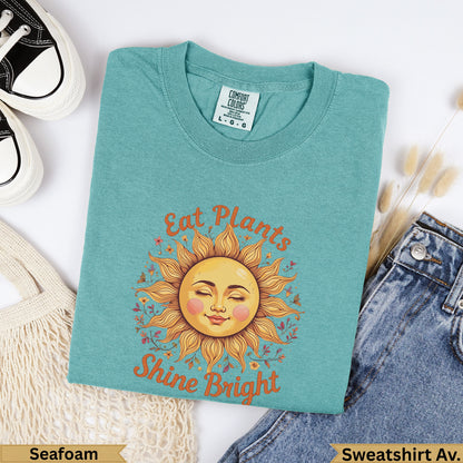 Teal t-shirt with sun graphic and text "Eat Plants Shine Bright".