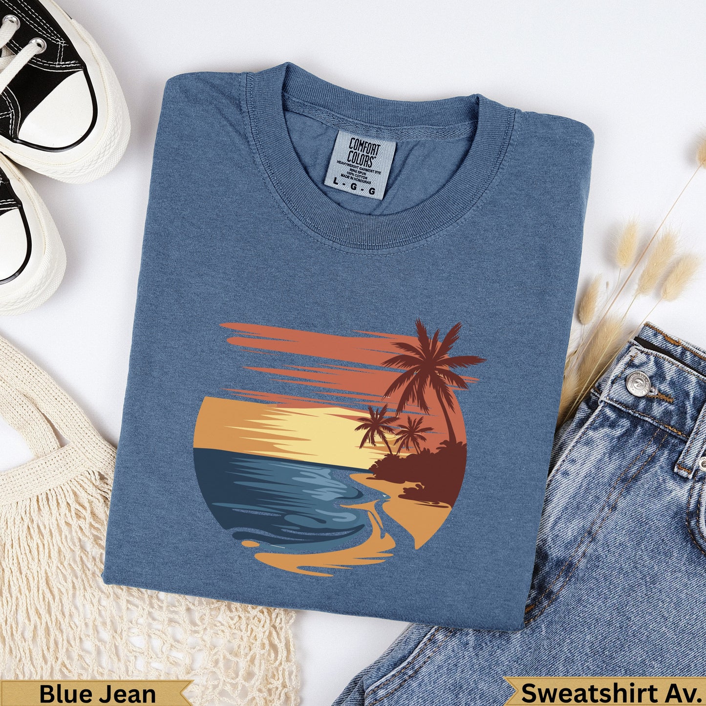 Blue t-shirt with beach sunset graphic and palm trees.