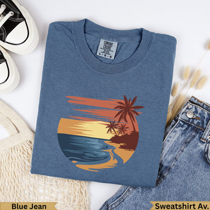 Blue t-shirt with beach sunset graphic and palm trees.