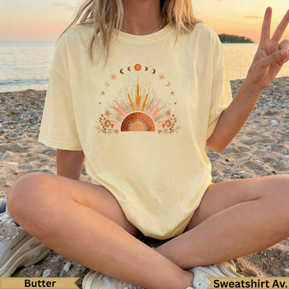 Light yellow graphic t-shirt with sun, moon, and celestial design.