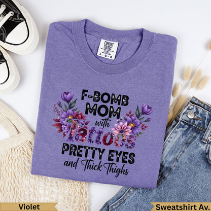 Lavender t-shirt with "F-BOMB MOM with tattoos PRETTY EYES and Thick Thighs" text.