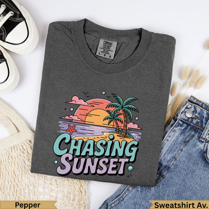 Dark grey t-shirt with "Chasing Sunset" graphic featuring palm trees and a sunset.