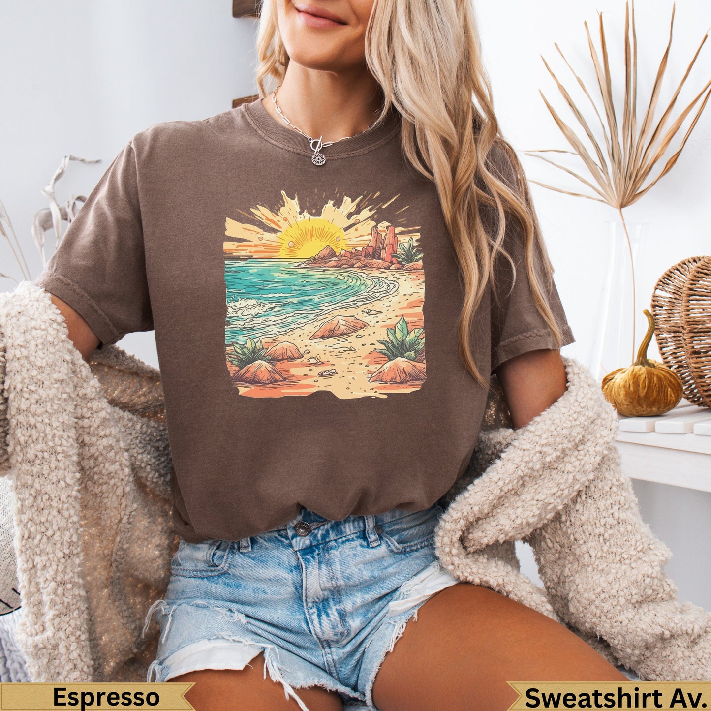 Brown t-shirt with sun setting over a beach landscape graphic.