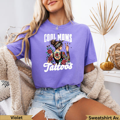 Purple t-shirt with "Cool Moms Have Tattoos" text and rose tattoo graphic.