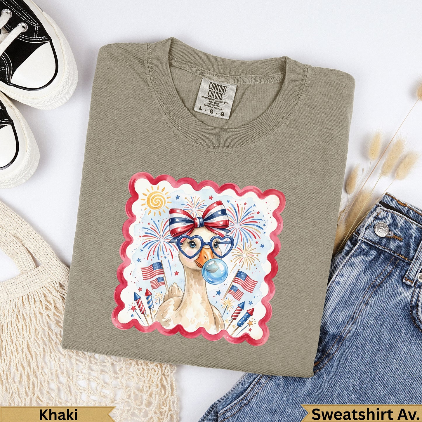 Khaki t-shirt with a cartoon goose wearing glasses and celebrating Fourth of July.