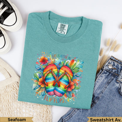 Teal t-shirt with colorful rainbow flip flops and floral design, reads "Life is better in flip flops".