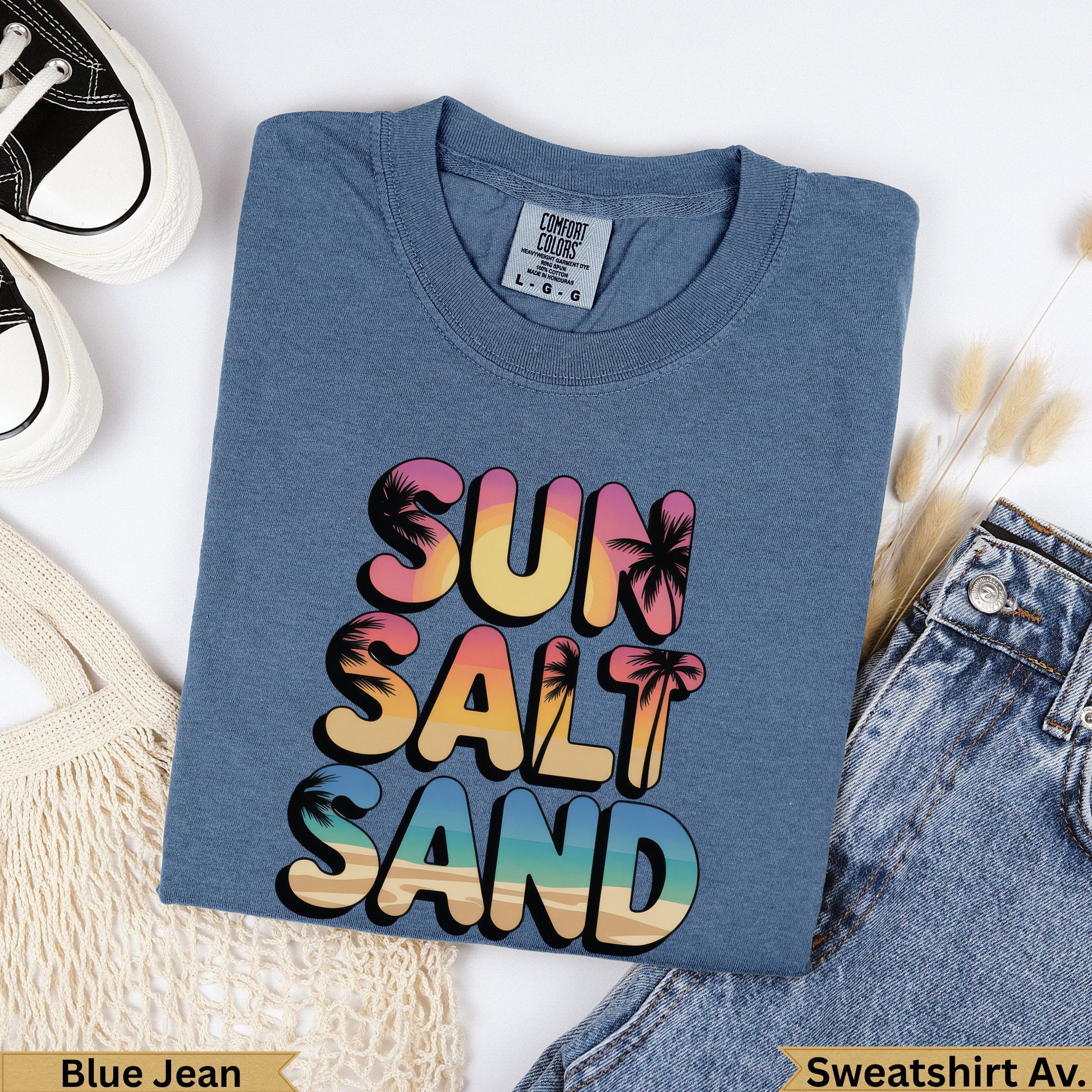 Blue t-shirt with "SUN SALT SAND" in colorful tropical font.