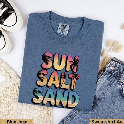 Blue t-shirt with "SUN SALT SAND" in colorful tropical font.